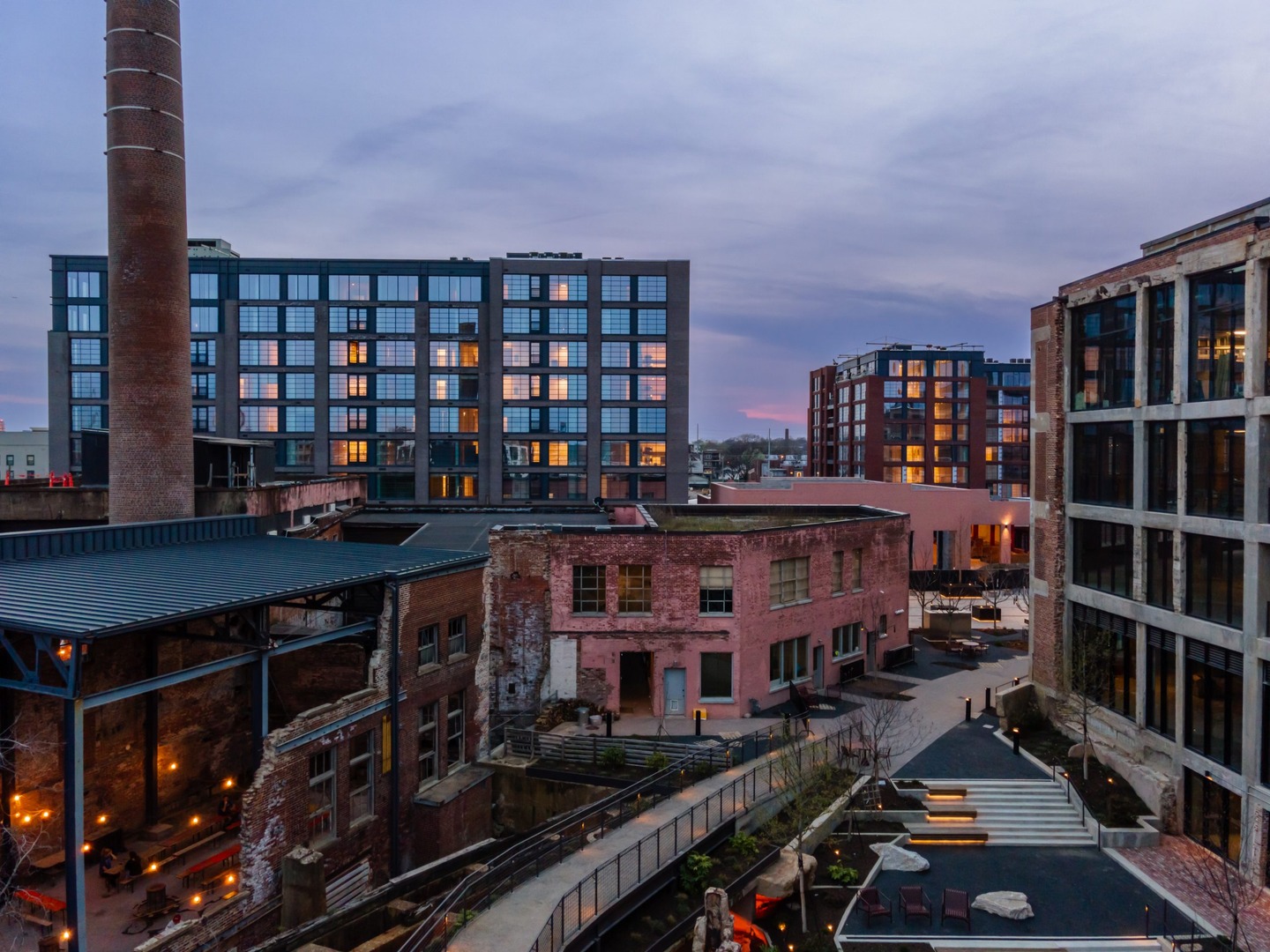 Industrial & residential buildings, a smokestack, & a courtyard near Neuhoff Residences